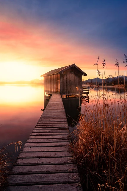 Plank to a boat house at sunrise at lake Chiemsee
