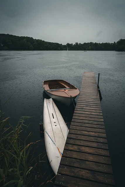 Moody Plank and some boats at a rainy day in Bavaria, Germany